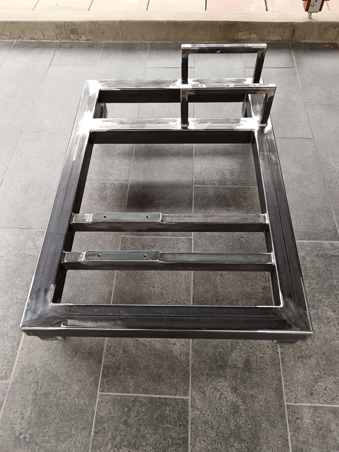 Overall view of welded steel base frame with integrated support structure and mounting crossmembers.